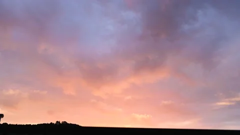 Red clouds moving at sunrise in 4k. Time lapse of warm clouds Stock Footage 235909456