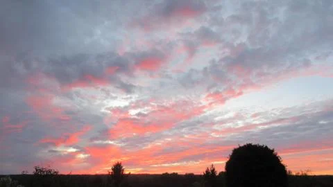 Red clouds at sunset, on a blue-gray sky background Stock Photos