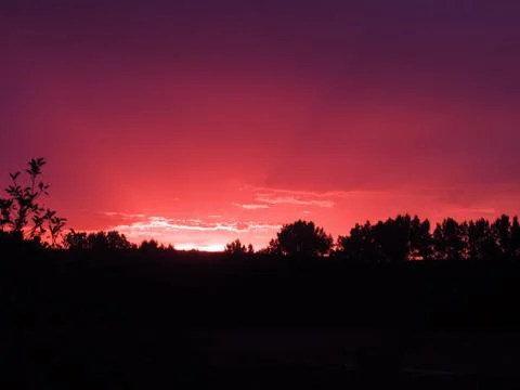 Red clouds at sunset, on a blue-gray sky background Stock Photos