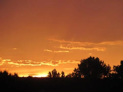 Red clouds at sunset, on a blue-gray sky background Stock Photos