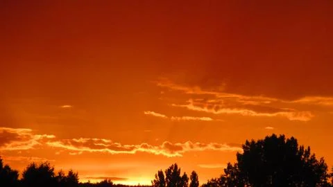 Red clouds at sunset, on a blue-gray sky background Stock Photos