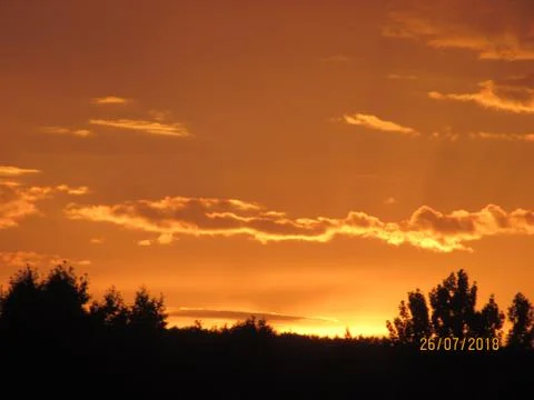 Red clouds at sunset, on a blue-gray sky background Stock Photos