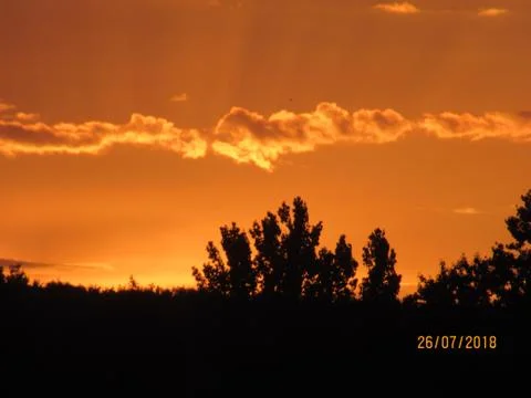 Red clouds at sunset, on a blue-gray sky background Stock Photos