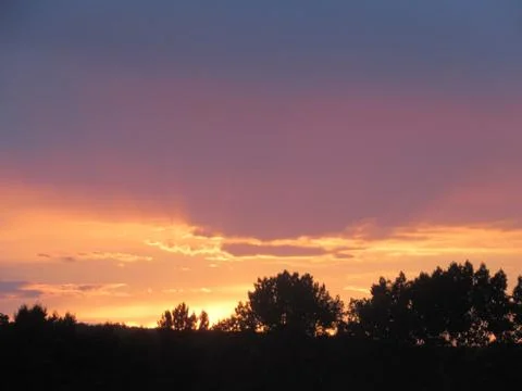 Red clouds at sunset, on a blue-gray sky background Stock Photos