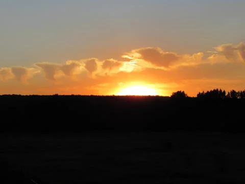 Red clouds at sunset, on a blue-gray sky background Stock Photos