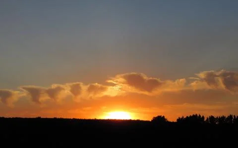 Red clouds at sunset, on a blue-gray sky background Stock Photos