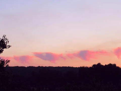 Red clouds at sunset, on a blue-gray sky background Stock Photos