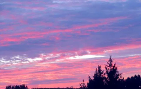 Red clouds at sunset, on a blue-gray sky background Stock Photos