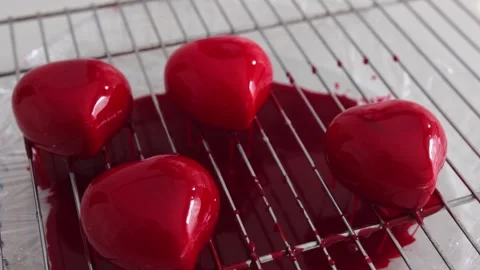 A red coating flows through the grid from the heart-shaped cupcakes Stock Footage 308226092