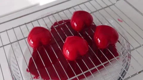 A red coating flows through the mesh from the heart-shaped cakes Stock Footage 308226068