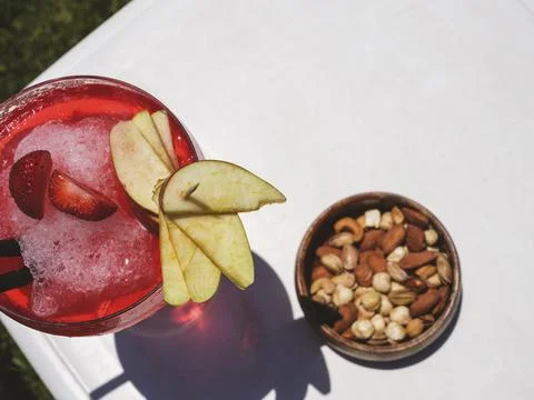 A red cocktail and nuts on the table Stock-Fotos