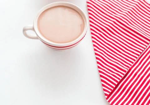 Red coffee cup over kitchen red strips towel. View from above. Isolated on white Stock-Fotos