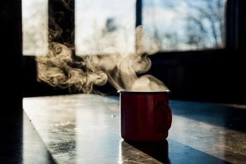 A red coffee mug sits on the table Stock Photos