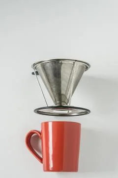 Red coffee mug on white background with filterless metal pour over drip cone Stock Photos