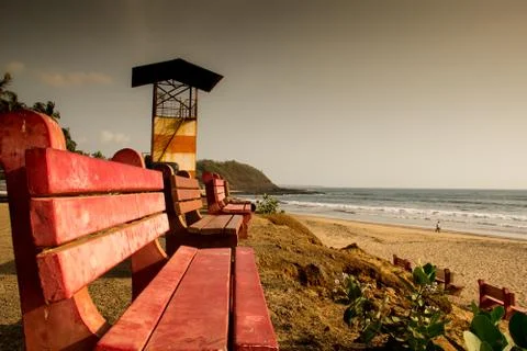 Red colored benches facing the sea at Velneshwar beach in Maharashtra, India Stock Photos