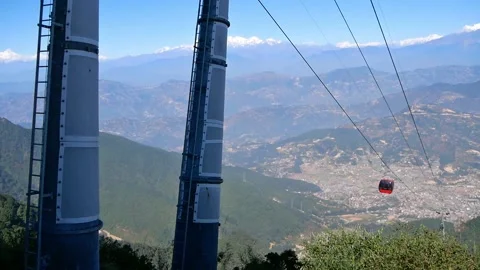 Red colored cable car moving up the hill near Chandragiri, Nepal panoramic view Stock Footage 146178811