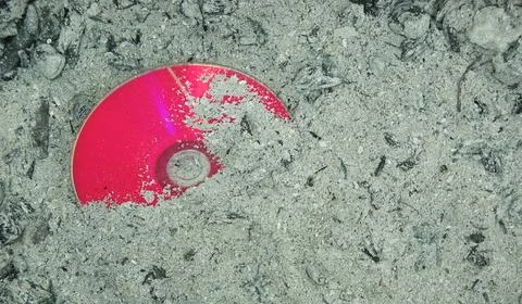 Red colored CD or DVD partially destroyed Stock Photos