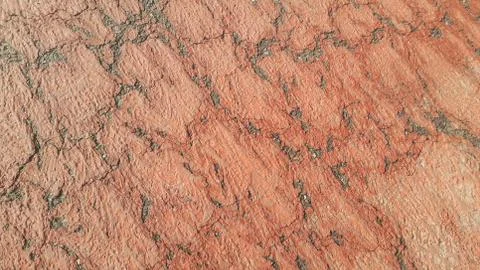 Red colored damaged road or paved pathway with crackes of different shpaes. C Stock Photos