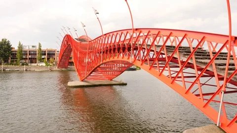 Red colored Python Bridge, modern steel footbridge with uncommon curved shape 库存影片 129981388