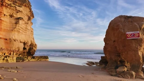 Red-colored rocks and a beautiful beach Praia dos Careanos at sunset, Portugal Stock Footage 277513393