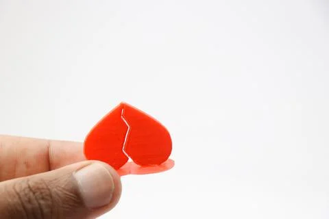 Red colour 3D model of a broken heart holding in a hand with white background Stock Photos