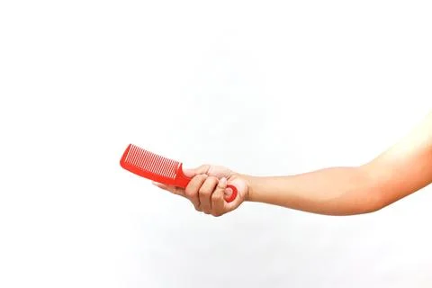 Red comb in hand: Styling tool on a clean, white background for hair care Stock Photos