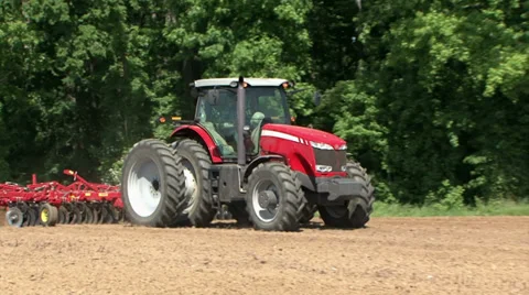 Red Commercial Tractor Pulling Plow in Dirt Field Sunny Day Stock Footage 37144409