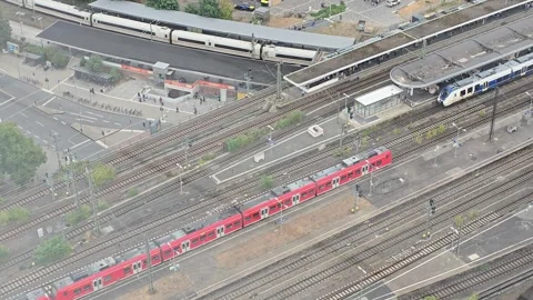 Red commuter train and long-distance trains at a railway junction in COLOGNE Stock Footage 345096223
