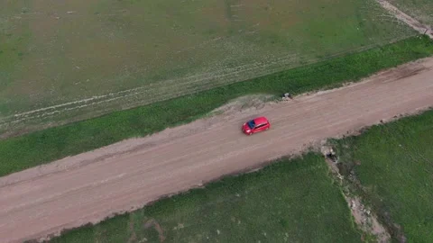 Red compact car on dirt road Stock Footage 154523407