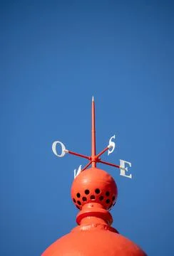 Red compass indicating wind direction in north, south, east, west. Stock Photos