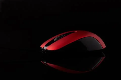 Red computer mouse on a black reflective background. Stock Photos