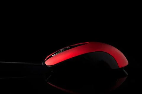 Red computer mouse on a black reflective background. Stock Photos