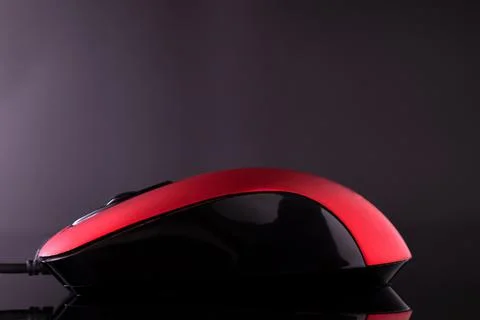 Red computer mouse on a black reflective background. Stock Photos