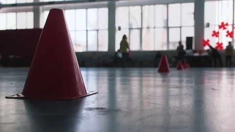 Red cones for the relay competitions on the floor in the sports hall in the Видео 102959746