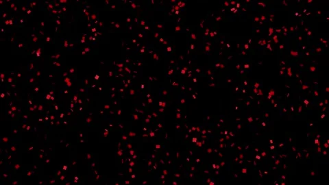 Red Confetti Falling Slowly Against a Solid Black Background Stock Footage 342218995
