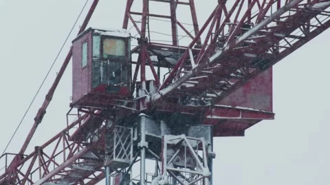 Red construction crane covered in snow during heavy snowfall, detailed view of Stock Footage 323913407