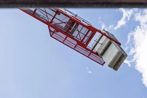 Red construction crane operating with concrete counterweights Fotos de archivo
