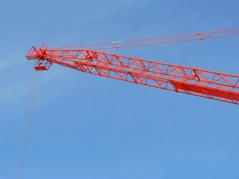 Red construction crane over blue sky Fotos de archivo