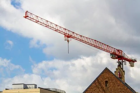 Red Construction Crane Towering Over Building Stock Photos