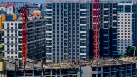 Red construction crane is working on a construction site. Builders and a tower Video stock 205566396