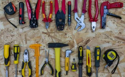 Red construction tools opposite yellow working tools on a osb background. Foto stock