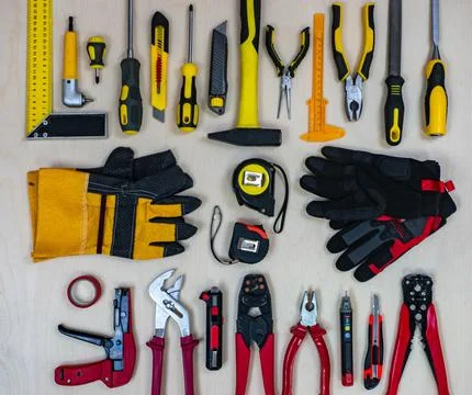 A red construction tools vs a yellow working tools on a plywood background. Stock Photos