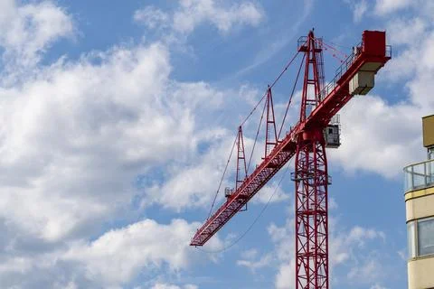 Red construction tower crane against blue sky Stock Photos