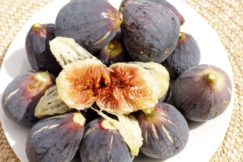 Red core of a black fig top view over many raw figs Stock Photos