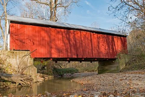 Red covered bridge spans a stream in Indiana Stock Photos