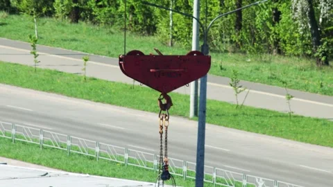 Red Crane Hook Sways With Chains Attached. Industrial Lifting Mechanism Detail 스톡 동영상 323912749