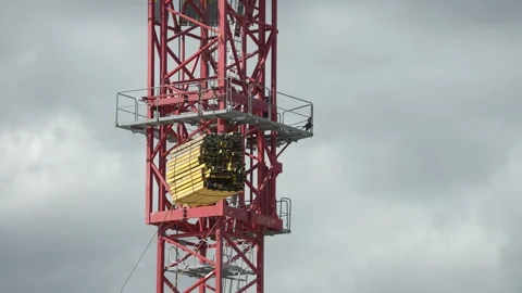 Red Crane pulling yellow pallete Stock Footage 241915913