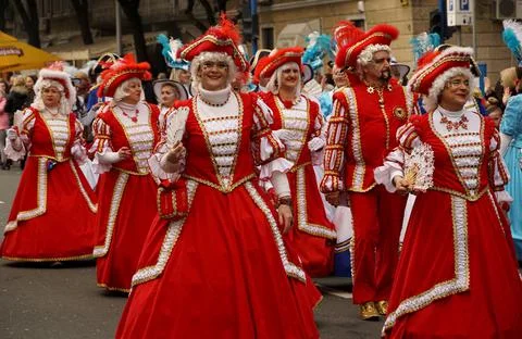 Red crinoline dresses on the medieval ladies, costumes in the carnival parade Stock Photos