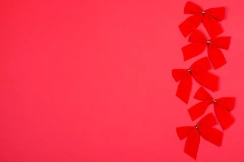 Red Cristmas bows on background of the same color. Stock Photos