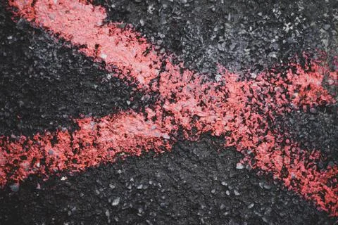 Red cross on the black road surface at the cover screw Stock Photos